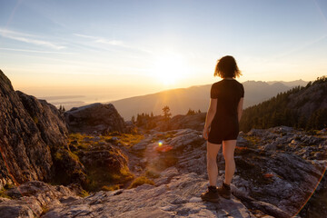 Adventurous Woman Hiker on top of Canadian Mountain Landscape. Sunny Sunset Sky. Top of Mt Seymour...
