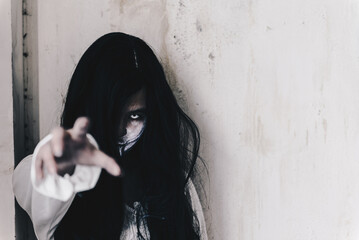 Woman in ghost or zombie on halloween festival at dark abandon place, threatening and wants to...