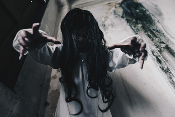 Woman in ghost or zombie on halloween festival at dark abandon place, threatening and wants to attack you. Horror or halloween festival concept.
