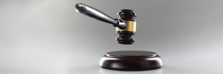 Brown wooden judge's gavel on a gray background