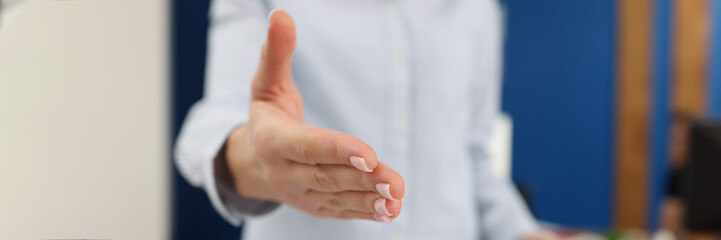 Naklejka premium Businesswoman stretches out her hand with a manicure, blurry