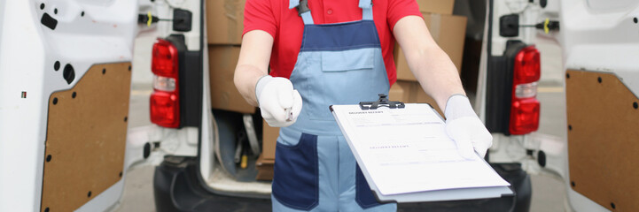 The delivery man holds out documents for signature