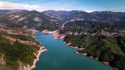 Fototapeta premium The water reservoir Lake Bovilla surrounded by mountains, blue sky, in Albania