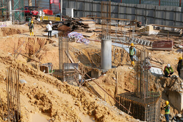 JOHOR, MALAYSIA - MARCH 5, 2022: Steel reinforcement bar is one of the materials used to build building pile caps. Construction workers tie the reinforcement bar using tiny steel wire.