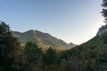 Landscape with rugged mountains and forest at sunrise