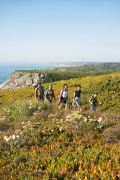Happy family of five hiking in mountains in summer. Parents with children trekking outdoors. Active family weekend concept
