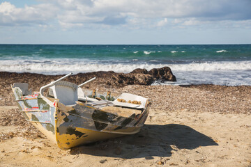 Fototapeta na wymiar Abandoned fishing boat on the beach of Paphos in Cyprus
