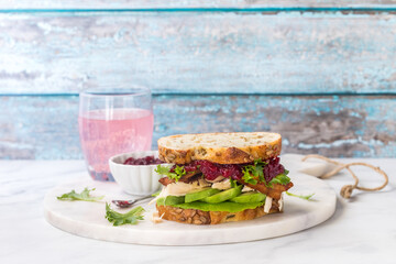 A turkey and bacon club sandwich served with a pink grapefruit spritzer.