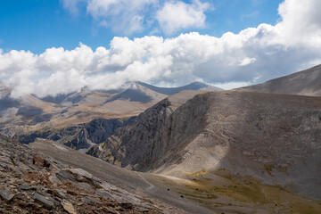 Trekking on mystical hiking trail leading to Mount Olympus (Mytikas, Skala, Stefani) in Mt Olympus National Park, Thessaly, Greece, Europe. Panoramic view of the cloud covered slopes and rocky ridges