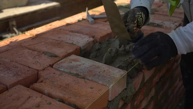builders lays bricks on a construction site