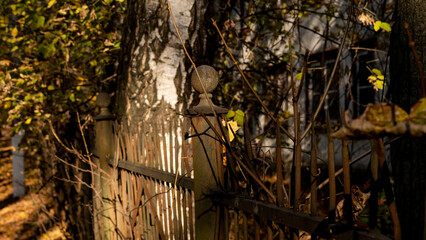 Old fence near the old building and autumn foliage