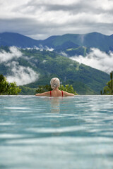 girl in the pool against the backdrop of mountains