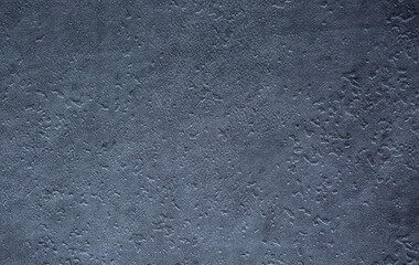 Dark background of decorative plaster with abstract spots. Unusual black or gray wall texture with beautiful patterns, creative surface background. Finishing coating for building cladding.