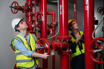 Engineers inspecting the inside plumbing and water valves of an industrial facility.