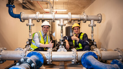 Portrait of Engineers inspecting the inside plumbing and water valves of an industrial facility.