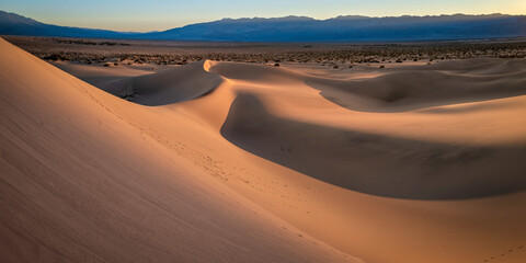 Mesquite Flat Sand Dunes and abstract geometry of curving arid desert terrain at sunset in Death Valley National Park, California