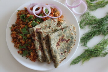 Dil Paratha served with scrambles cottage cheese and garnished with coriander leaves.