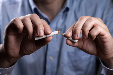 タバコを折って禁煙を決意する男性