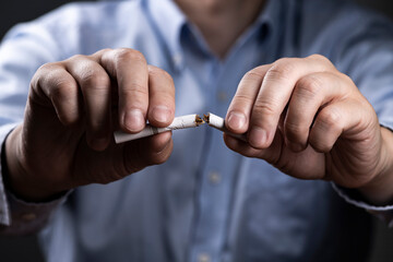 タバコを折って禁煙を決意する男性