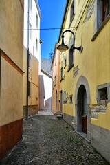 Fototapeta na wymiar A narrow street between the old stone houses of Frosolone, a medieval village in the Molise region of Italy.