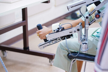 woman wear machine arm for physical therapy. By defining how a robot driven moving technique can be improved to achieve better results in physical rehabilitation. - 538636112