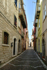 Fototapeta na wymiar A narrow street between the old stone houses of Frosolone, a medieval village in the Molise region of Italy.