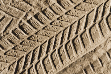 Sand tyre mark background. Tire track shape. Trail lines on dry brown sand pattern. Road...