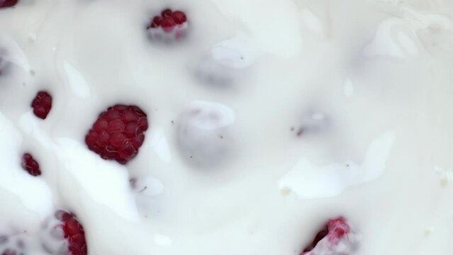 Pink raspberry floating dessert closeup. Summer berries milk yoghurt breakfast