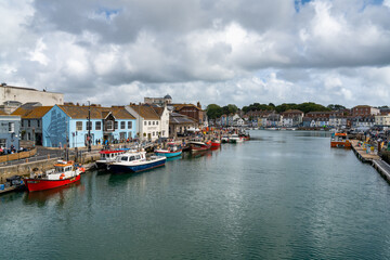 Fototapeta na wymiar downtown Weymouth and fishing boats on the River Wey in Dorchester