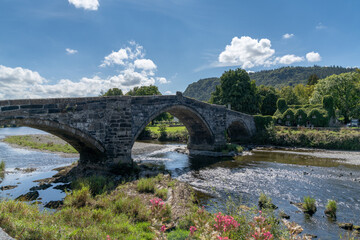 the historic Pont Fawr bridge and ivy-covered house on the River Conwy in North Wales