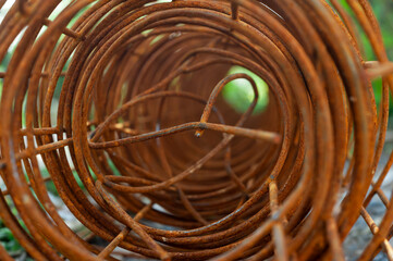 selective focus of roll of rusty construction rebar on ground