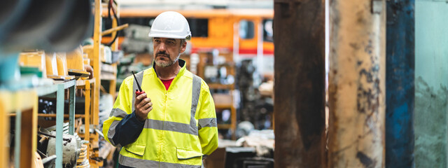 professional technician engineer with safety hard hat working to maintenance construction equipment...