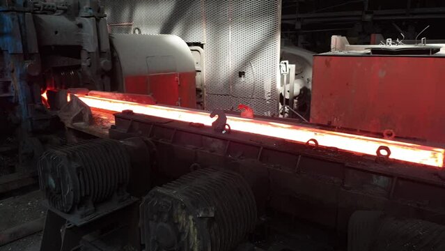 hot metal moves on rollers and enters the rolling stand, metallurgical production. Hot rolling of metal. production of long products of metal. hot metal billet