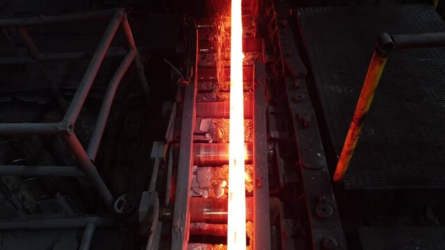 hot metal billet moves on rollers in a hot metallurgical shop. rolling mill, metallurgical plant, steel mill. iron and steel industry