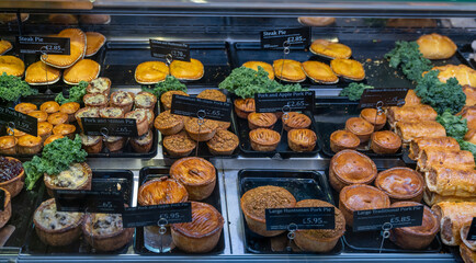 close-up view of a butcher shop showcase with a variety of steak and pork pies
