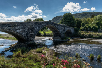 Fototapeta na wymiar the historic Pont Fawr bridge and ivy-covered house on the River Conwy in North Wales