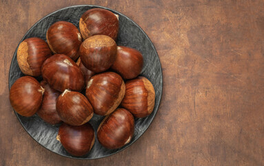 Chestnuts on on an old board with copy space. Autumn mood.  Horse chestnuts top view