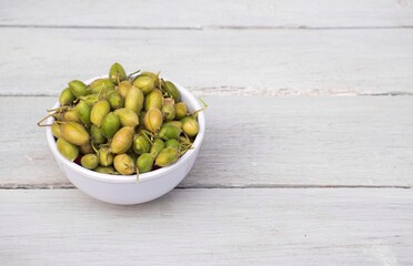 Raw Chickpea or Garbanzo Bean Pods in Bowl Isolated on White Wooden Background ,Also Known as Bengal Gram or Egyptian Pea