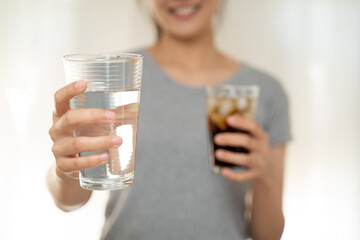 Close up slim woman hand choose water avoid cola soft drink high sweet sugar for good health diet and calories control