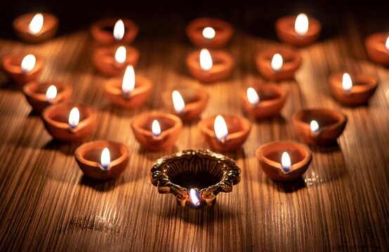 Happy Diwali Or Deepavali Festival Diya With Glowing Lit Flame Or Oil Lamps Isolated On Wooden Table In Horizontal Orientation, Deepavali Or Diwali Festival Celebration Concept, Festival Of Light