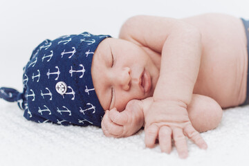 sleeping newborn in anchor clothes - obrazy, fototapety, plakaty