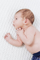 newborn lies on blanket and looks ahead