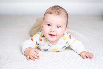 baby raised up in prone position smiling with joyful look