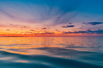 Obraz premium Beautiful sunset ocean water surface. Tranquil summer meditation relaxing seascape. Exotic sunrise beach sun rays, sea and horizon. Amazing nature view, waves colorful sky. Majestic beach coast shore 