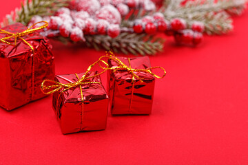 Christmas tree branch with toys and a gift on a red background