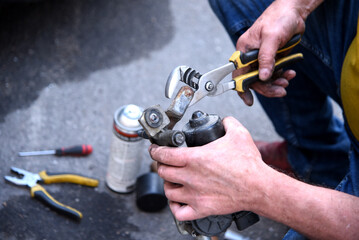 Male hands of a car mechanic with tools in outdoor work