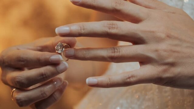 marriage hands with rings. Engagement, marriage and wedding concept. Ring wedding. Close-up slim female Caucasian young hands touching engagement ring on finger. Solitaire diamond ring in women hand