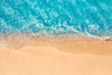 Summer seascape beautiful waves, blue sea water in sunny day. Top view from drone. Sea aerial view, amazing tropical nature background. Beautiful bright sea waves splashing and beach sand sunset light - obrazy, fototapety, plakaty