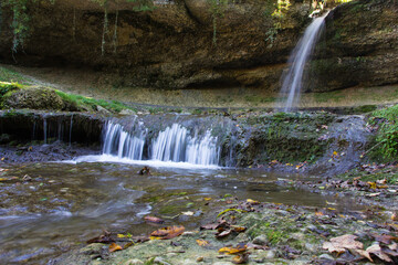 Obraz premium Wasserfall in den Bergen mit Bachlauf