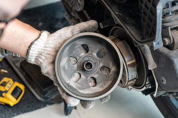 mechanic check auto Transmission system or Rear Clutch Pulley of  scooter Motorcycles in garage. maintenance, repair motorcycle concept in garage .selective focus